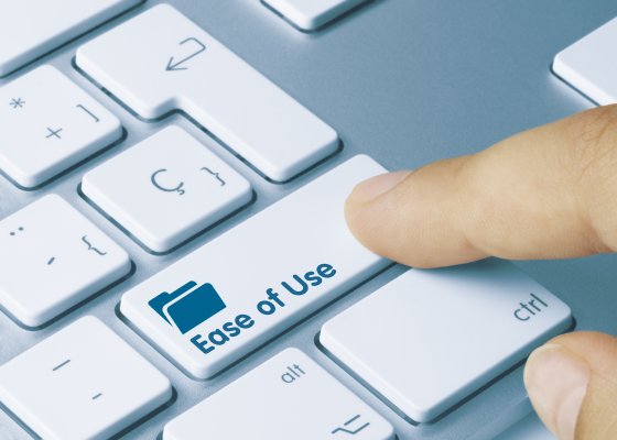 Finger pressing down on a computer button labeled ease of use.