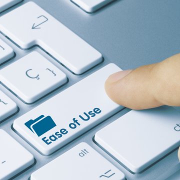 Finger pressing down on a computer button labeled ease of use.