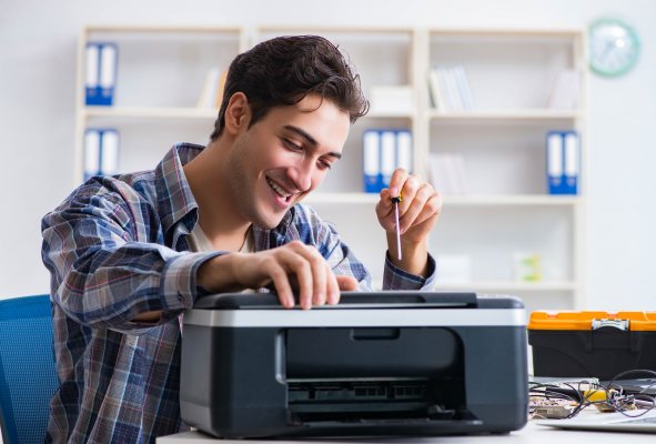 Guy fixing broken fax machine. 