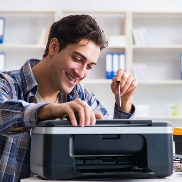 Guy fixing broken fax machine. 