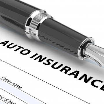 Picture of pen above auto insurance agreement.