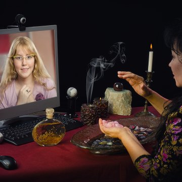 woman reading through laptop online psychic services kasamba keen
