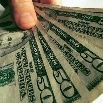 payday loans check into cash hand holding 50 dollar bills money