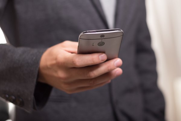 man, suit, on smartphone, background check, instant checkmate