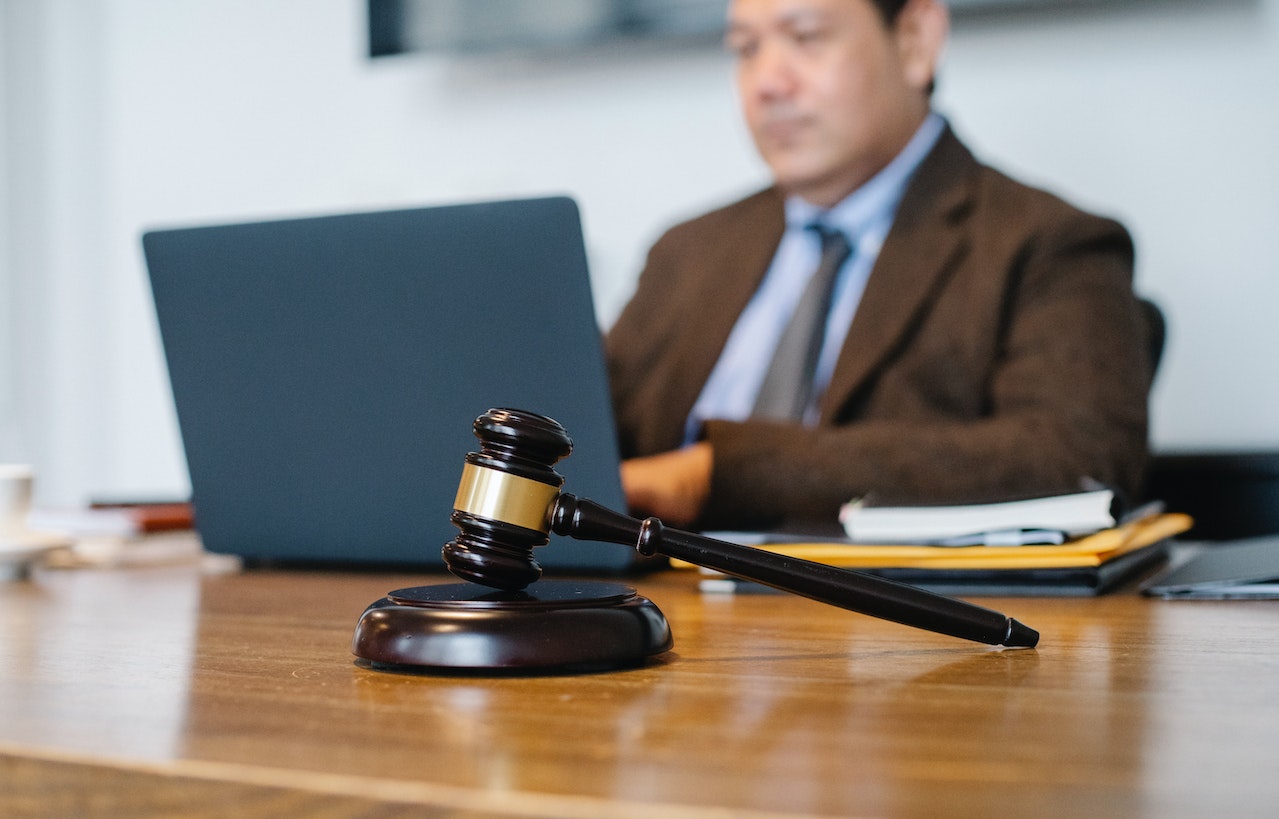 lawyer sitting near a judges table on a laptop