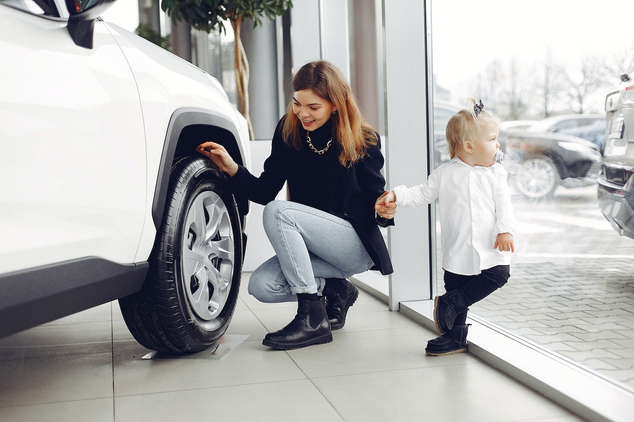 checking a cars tires for a road trip