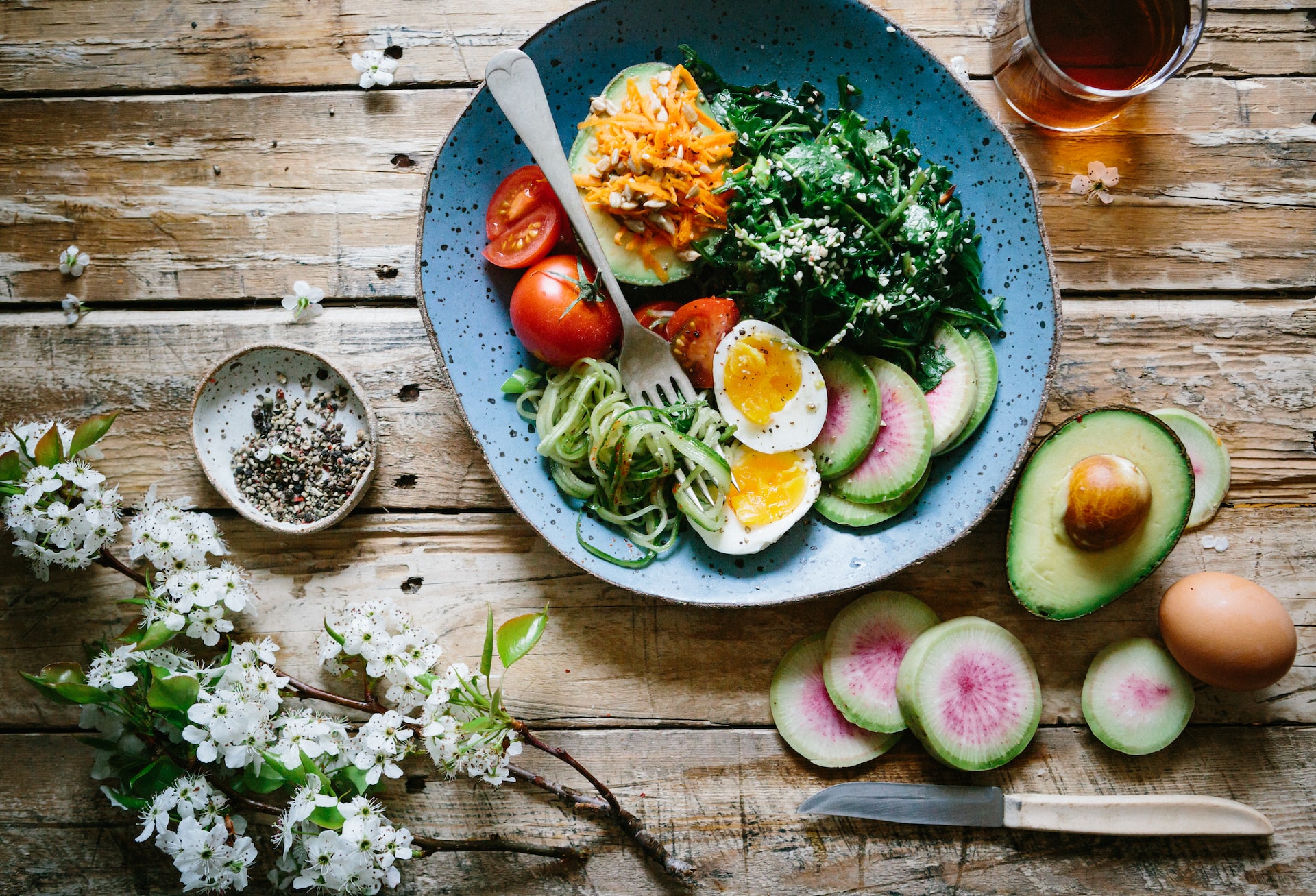 a bowl of healthy food with eggs, avocados, and other veggies