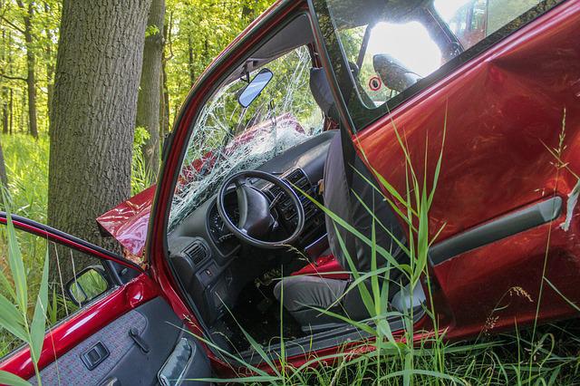red car that has crashed into a ditch