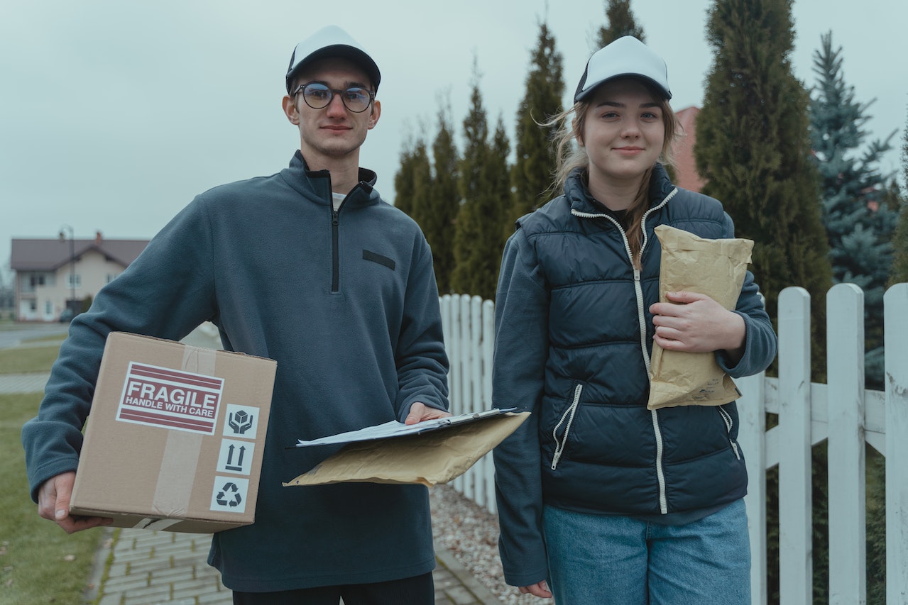 people carrying shipping box