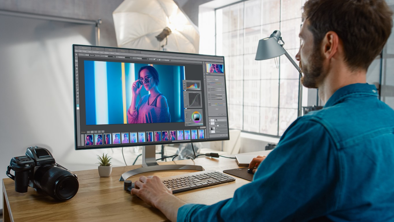 person working on adobe photoshop on a desktop computer