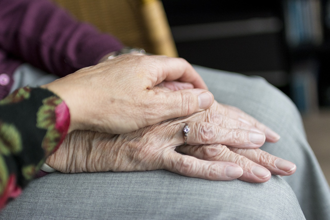 old people resting hands on another folded pair of hands