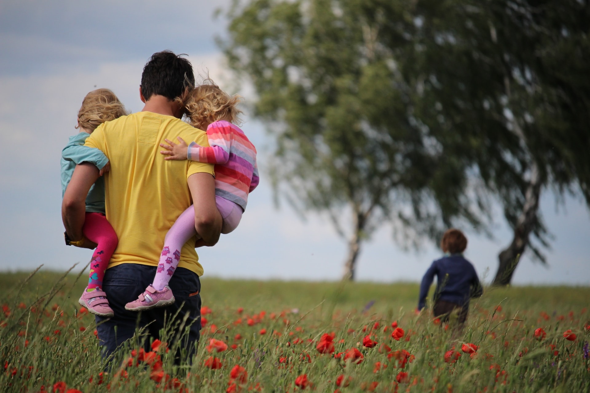 person carrying kids while playing outside 