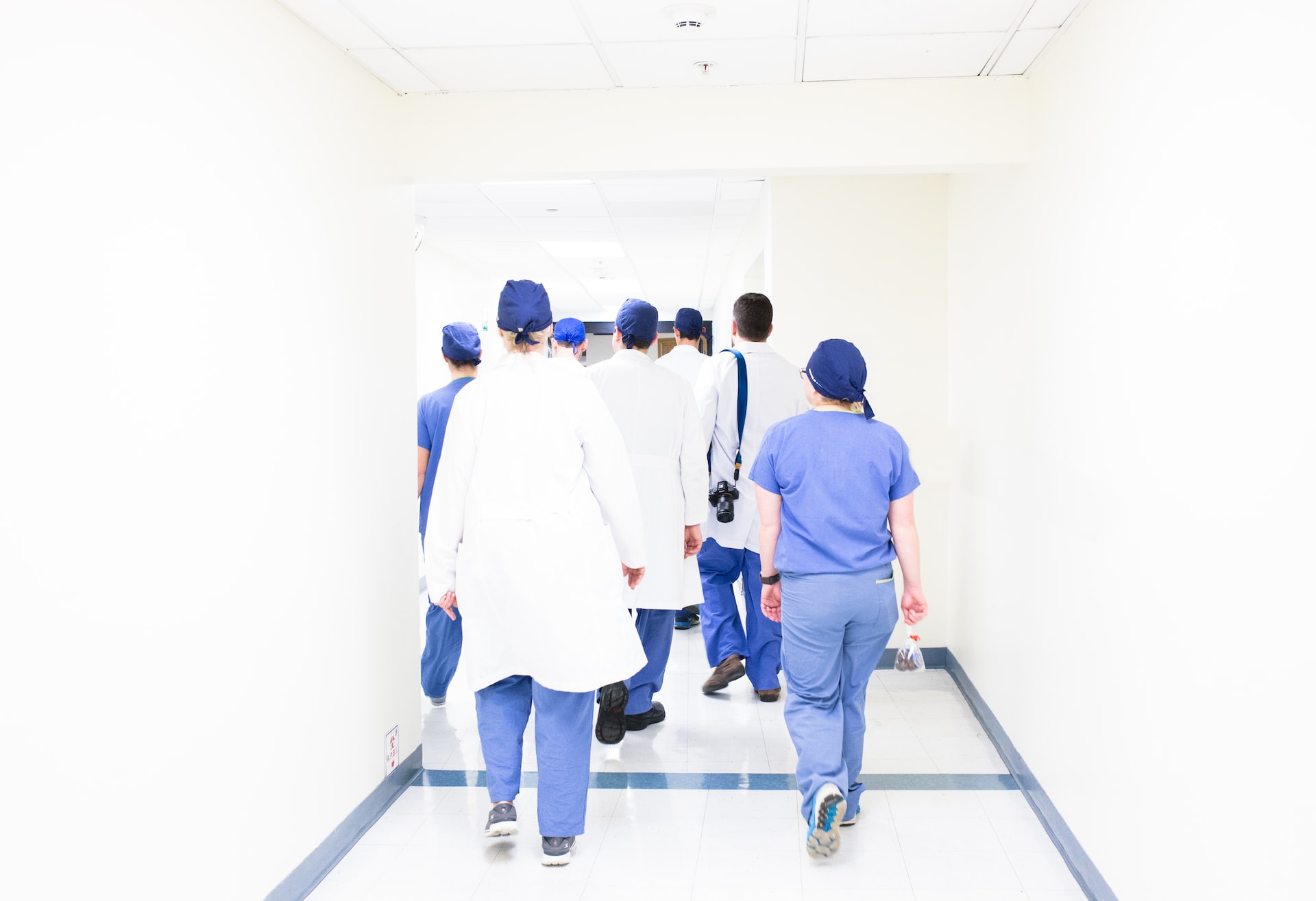 hospital team walking down a white hallway in scrubs