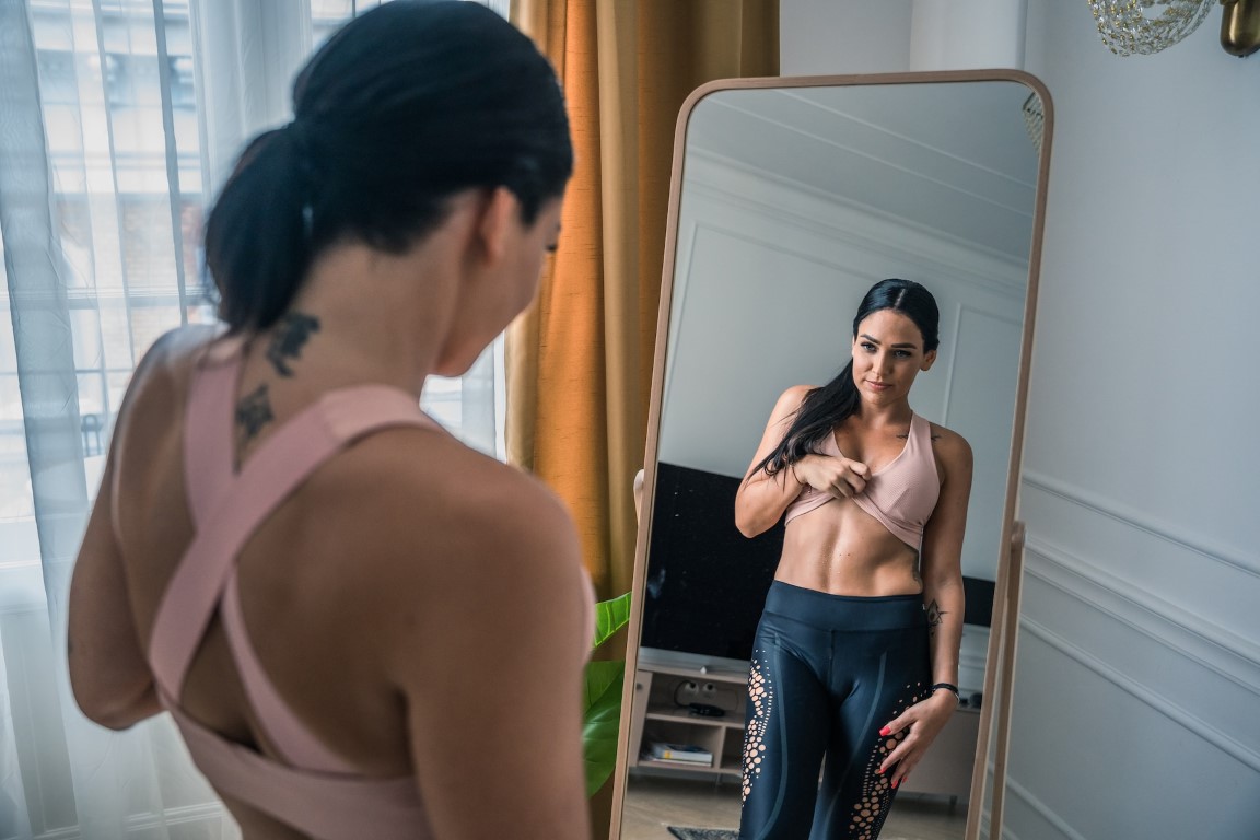 person looking at body in the mirror