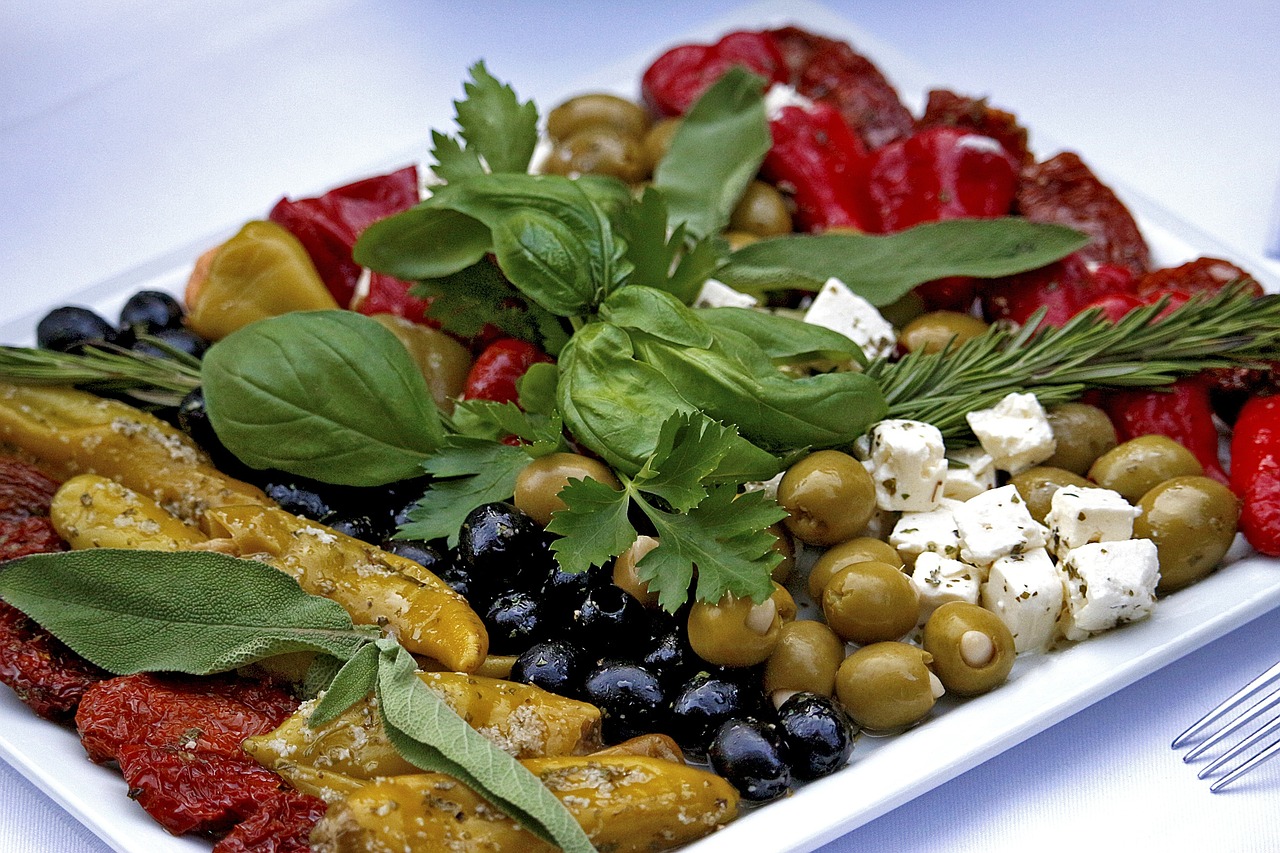 meat with olives and cheese on a large white plate