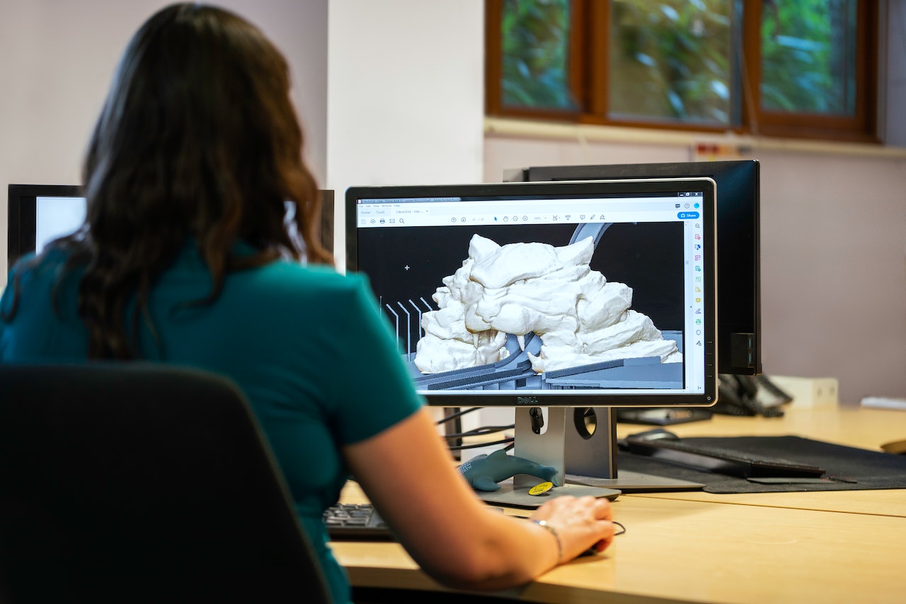 person modeling a 3d object on their computer 
