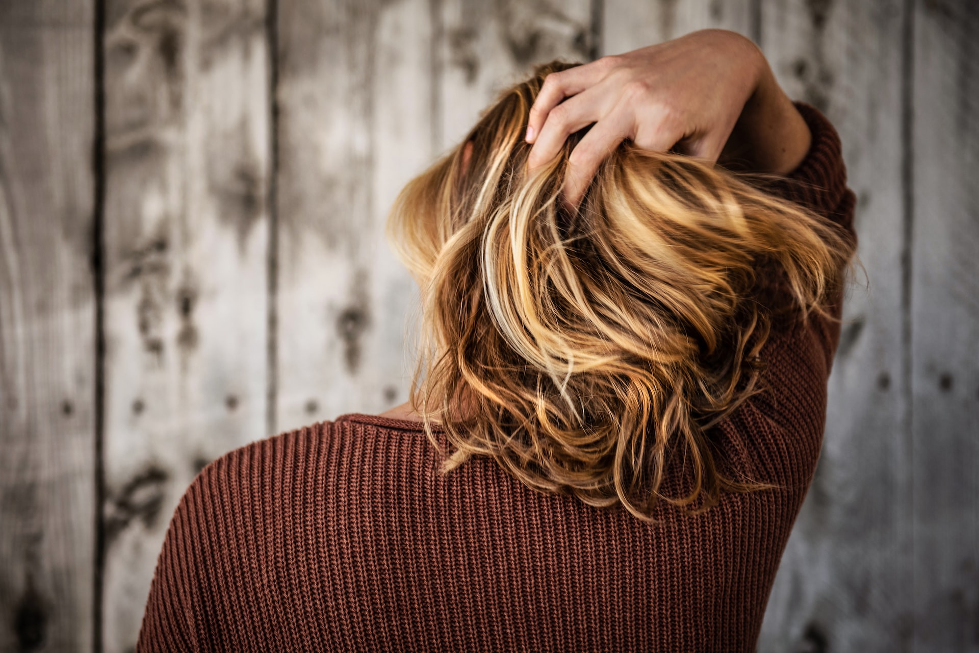 back of someones head with their hand run through their hair