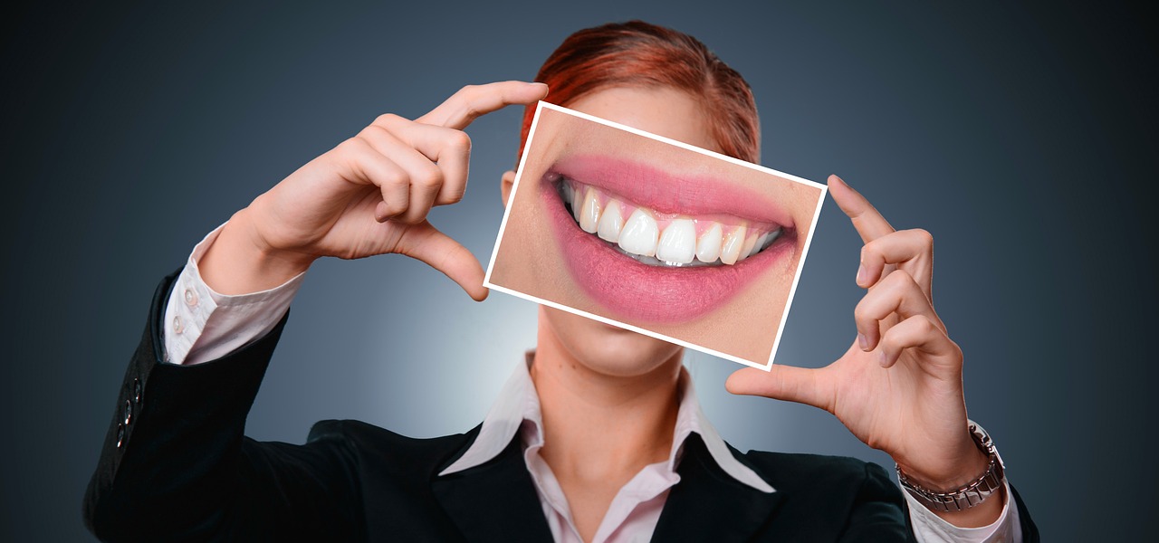 person holding up a picture with straight white teeth on it