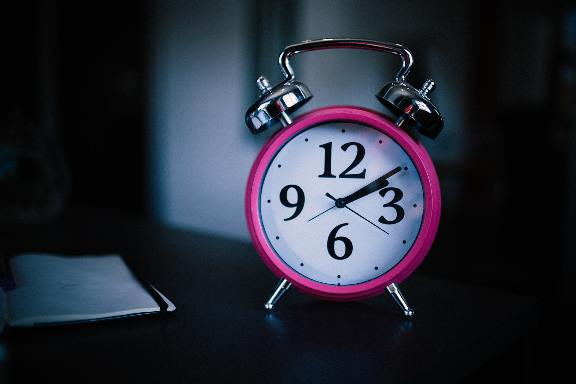 an alarm clock beside the bed