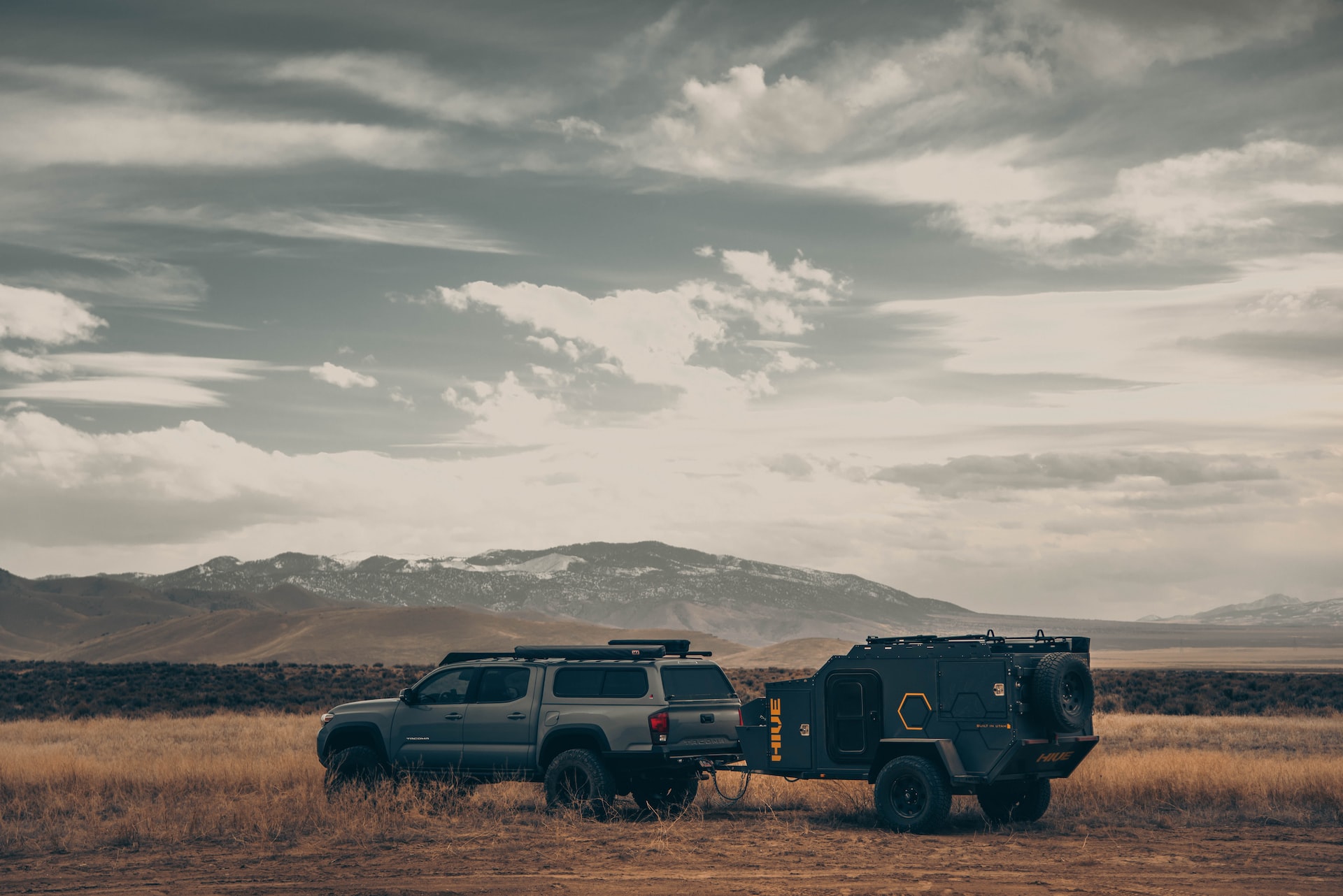 a truck pulling a camper in the outback