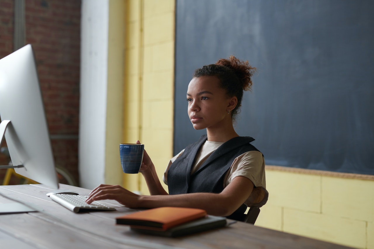 person sitting at their desk in front of a class