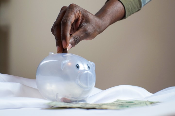 hand placing change in a piggy bank