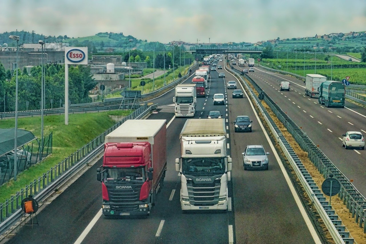 two trucks driving down a three lane highway