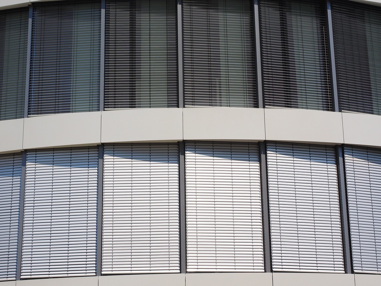 large glass windows with shades drawn to keep inside cool