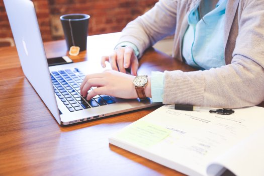 woman typing on laptop at the desk, intelius, background check
