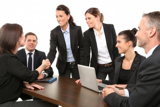 men and women in suits around a desk shaking hands, payday loans, sofi